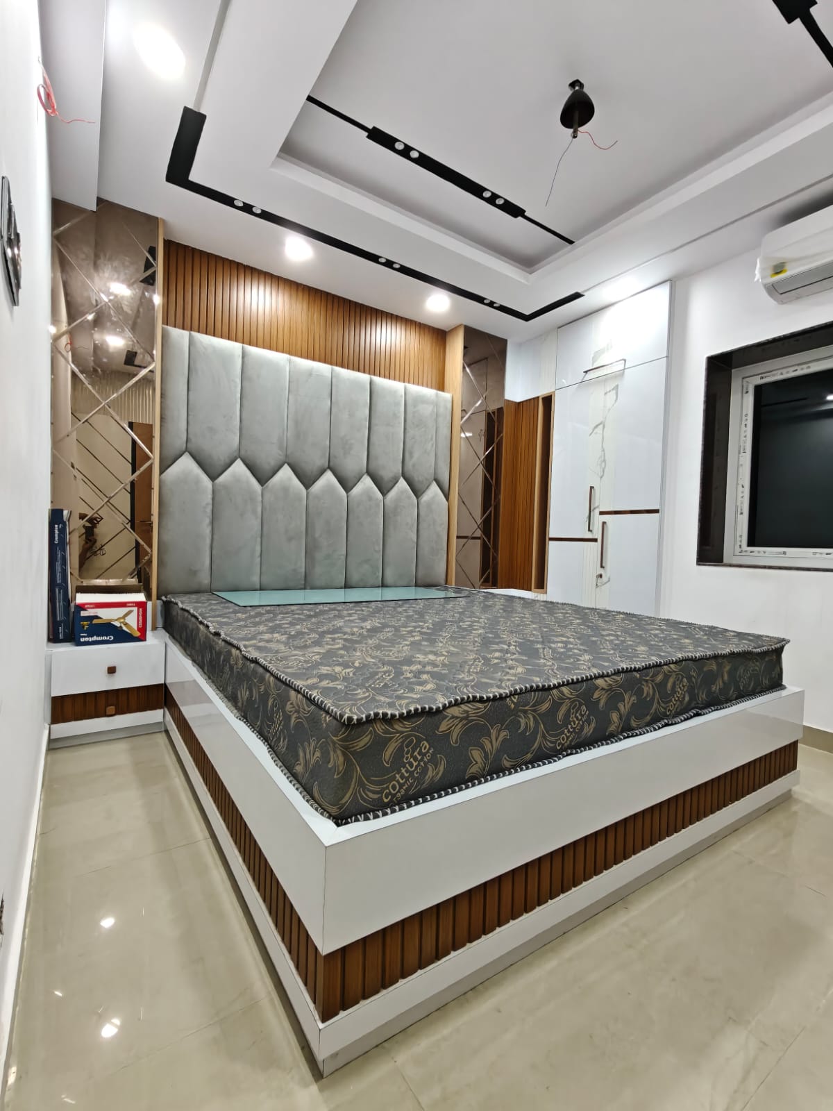 Bedroom interior with padded headboard, wardrobe and false ceiling